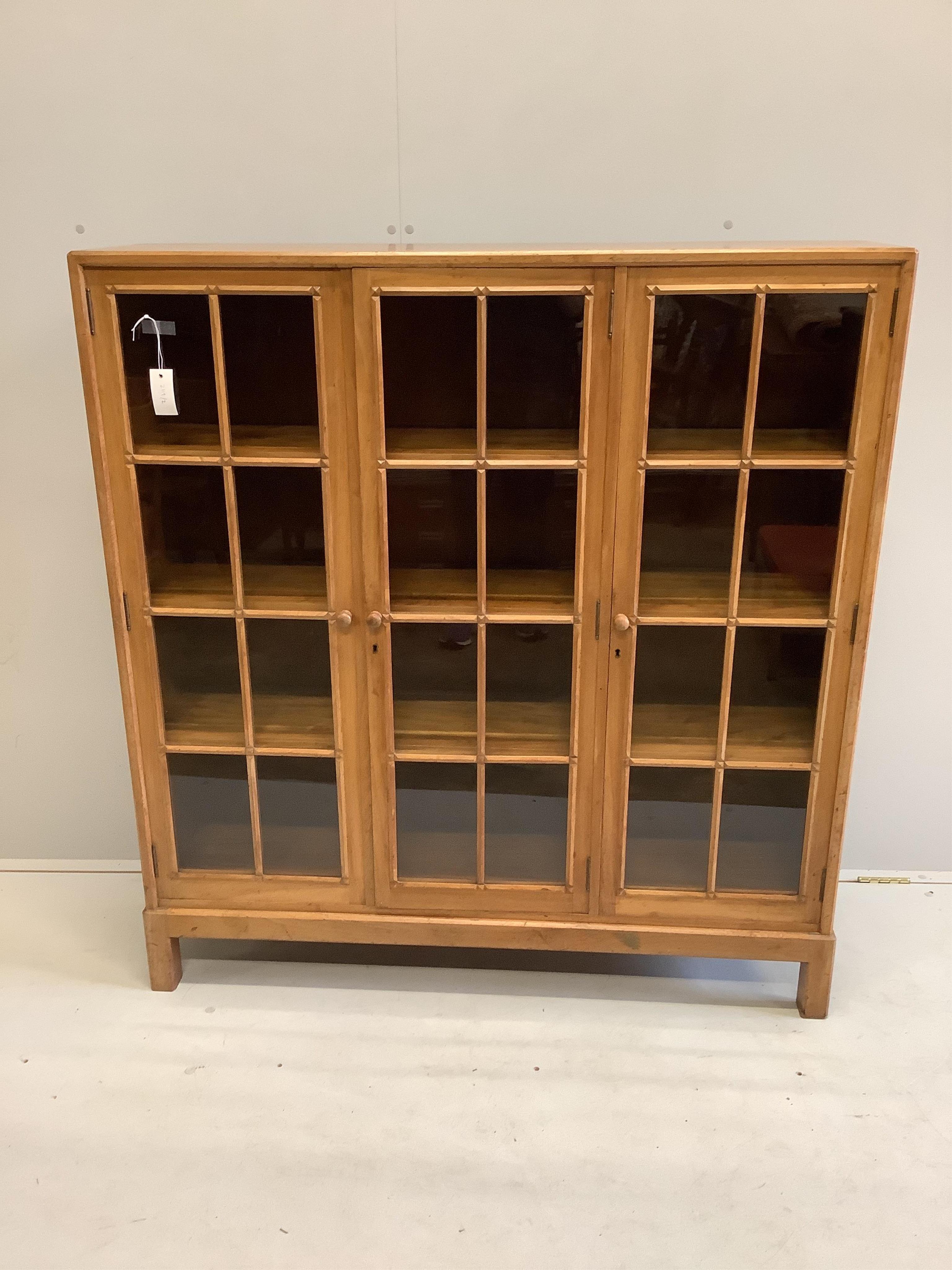 An early 20th century Heal & Son, London glazed walnut three door bookcase, width 122cm, depth 29cm, height 130cm